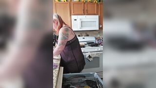 Husband sneaks in on wife doing dishes