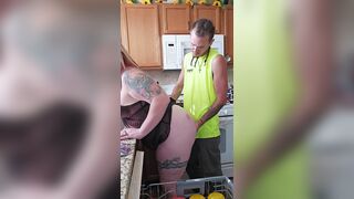 Husband sneaks in on wife doing dishes